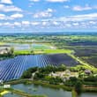 Glistening atop the water at a solar-fishery farm, blue photovoltaic panels soa…