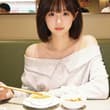 盛夏也抵挡不住奔赴火锅的热情，店内冷气隔绝室外滚滚热浪，安心享用热辣美食。浅灰色露肩针织柔和慵懒，利落短发清爽适配夏季，面前汤锅咕嘟沸腾，各式蘸料摆放整齐。在…