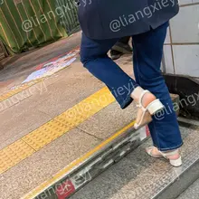 一身西装外套牛仔裤，却穿了双白色一字带凉鞋，从这个小姐姐的身上能感受到一种清冷和性感之间的反差，另外有一说一，这脚也是相当极品了